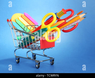 trolley with school equipment on blue background Stock Photo