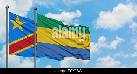 Congo and Gabon flag waving in the wind against white cloudy blue sky together. Diplomacy concept, international relations. Stock Photo