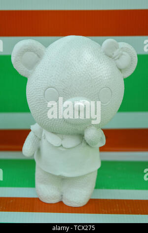 Young bear toy on the stripes background. Stock Photo