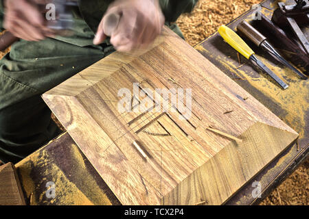 wood chisel carpenter tool hammer in hand working wooden background Stock Photo