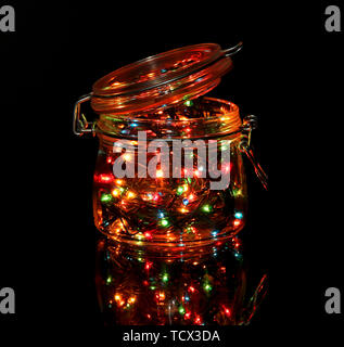 Christmas lights in glass bottle on dark background Stock Photo