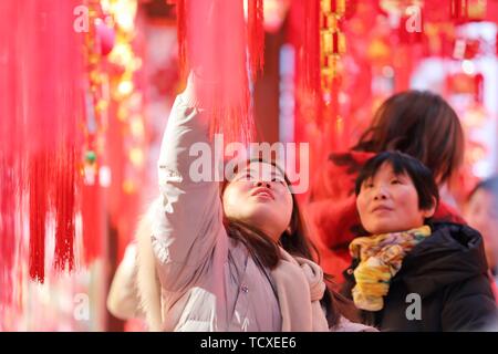 Recently, with the advent of the Spring Festival, the general public of Hefei City, Anhui Province came to the Chenghuang Temple to buy traditional festive supplies such as Spring Festival couplets, Chinese knots, lanterns and so on. Stock Photo
