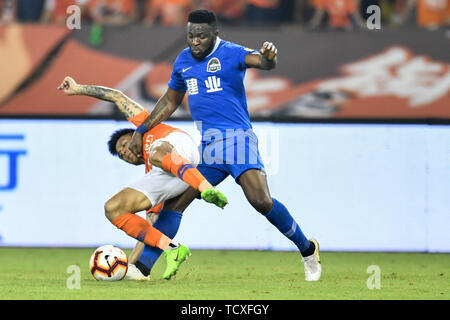 Cameroonian football player Franck Ohandza, right, of Henan Jianye challenges a player of Wuhan Zall in their 4th round match during the 2019 Chinese Football Association Super League (CSL) in Wuhan city, central China's Hubei province, 8 June 2019.  Wuhan Zall played draw to Henan Jianye 0-0. Stock Photo