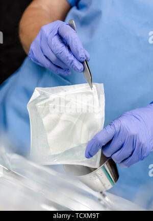 Nurse taking gauze sterile in a hospital, conceptual image Stock Photo