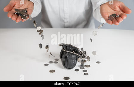 Hand pour coins falling out in wallet. Female hands and falling coins Stock Photo