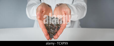 Hand pour coins falling out in wallet. Female hands and falling coins Stock Photo