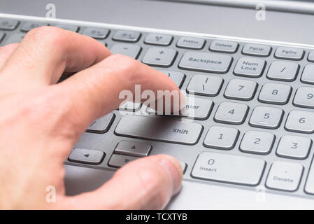 Close-up finger pressed on the return key of the computer keyboard. Stock Photo