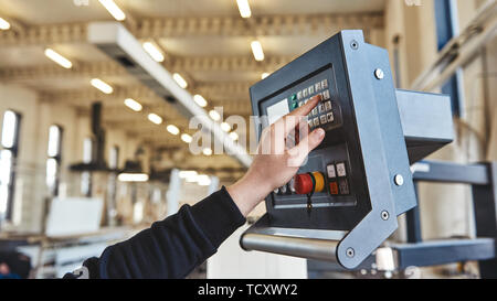 Man's hand pushing the button on remote control. Selective focus. Horizontal shot Stock Photo