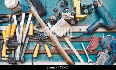 Close up of assorted tools for carpenter lying on the blue working surface. Horizontal shot Stock Photo