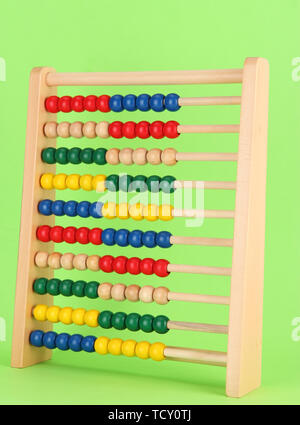 Bright wooden toy abacus, on green background Stock Photo