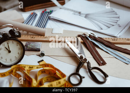 Tailor's tools, scissors, measure tape and ruler on the sartorial work table. Clothes designer items Stock Photo