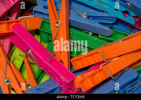 A handful of clothespins hanging clothes of various types of colors Stock Photo