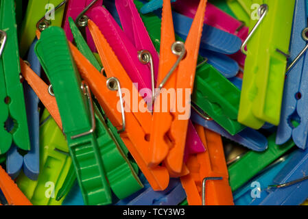 A handful of clothespins hanging clothes of various types of colors Stock Photo