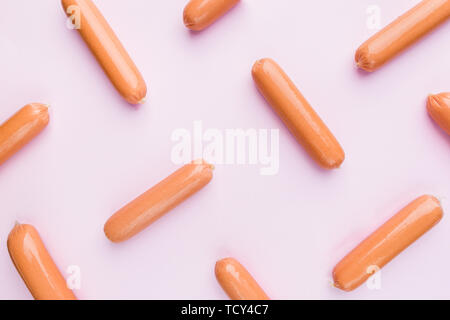 Raw sausages in polyethylene shell isolated on pink background. Top view, flat lay. Pin-up style background Stock Photo