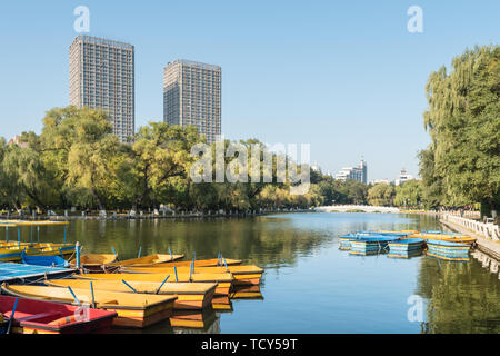 Autumn China Fushun early morning park river bank willow stone bridge cruise ship Stock Photo