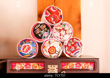 A stack of Korean traditional pillow embroidered with flowers on the wooden furniture Stock Photo