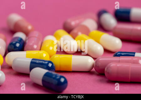 Medical pills yellow, blue and red on a colored background