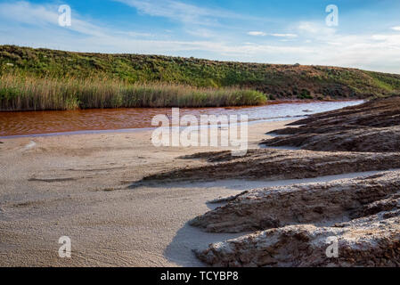 View of small red water river full of iron in beautiful steppe Stock Photo
