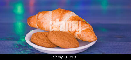 Treats for Santa concept. What do kids around world leave for Santa. Croissant and oat cookies on white plate. Winter holiday tradition. Sweets for Santa Claus and his helpers. Santa treats recipe. Stock Photo