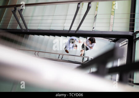 Businessman and Business woman go up the stairs Stock Photo