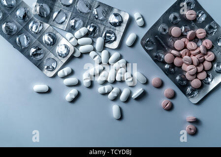 Top view of many prescription drugs, medicine tablets or vitamin pills in a pile and empty blister packs - Concept of healthcare, opioids addiction Stock Photo