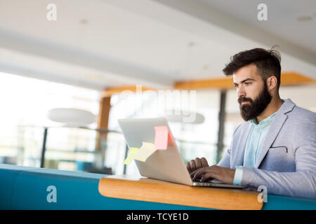 Handsome businessman working on laptop in office Stock Photo