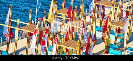 ROUEN, FRANCE - JUNE 8, 2019. Colorful wooden terrace with table, chairs and flags, ready for a street cafe or restaurant, during the Aramda time, int Stock Photo