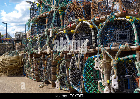 Lobster pots lined up on the jetty in the south bay at scarborough yorkshire england Stock Photo