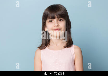 Adorable brown-eyed brown-haired little girl isolated on blue Stock Photo