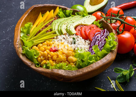 Healthy vegan food concept. Fruits vegetables background. Healthy vegan superfood bowl with quinoa, wild rice, chickpea, tomatoes, avocado, greens, ca Stock Photo