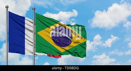 France and Brazil flag waving in the wind against white cloudy blue sky together. Diplomacy concept, international relations. Stock Photo