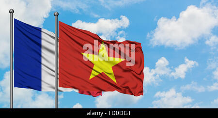 France and Vietnam flag waving in the wind against white cloudy blue sky together. Diplomacy concept, international relations. Stock Photo