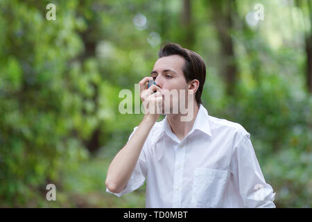 Young man is using a asthma inhaler Stock Photo