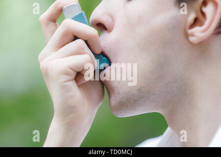 Young man is using a asthma inhaler Stock Photo