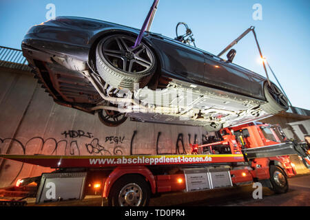 07 June 2019, Hessen, Frankfurt/Main: In the last light of day, a Mercedes CLS 550 previously seized by the police 'Autoposer Raser Tuner Control Unit' (KART) hangs on the hook of a tow truck. (Zu dpa 'Control unit KART on tour - expensive evening for Poser') Photo: Boris Roessler/dpa Stock Photo