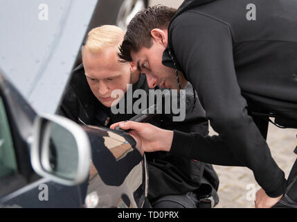 07 June 2019, Hessen, Frankfurt/Main: Nico Briesemeister (r) and a colleague use a flashlight to check the engine compartment of a vehicle that had caught the attention of the police officers in the city centre. Briesemeister is head of the police 'Control Unit Autoposer Raser Tuner' (KART), which is on the trail of racers and autoposers in the Main metropolis with civilian vehicles. (Zu dpa 'Control unit KART on tour - expensive evening for Poser') Photo: Boris Roessler/dpa Stock Photo