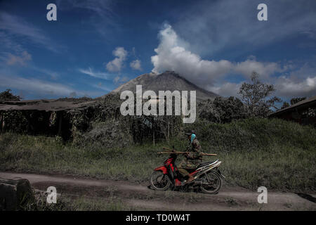 Beijing, Indonesia. 10th June, 2019. A man rides his motorbike after the eruption of Mount Sinabung volcano in Karo, North Sumatra, Indonesia, June 10, 2019. Credit: Albert Damanik/Xinhua/Alamy Live News Stock Photo