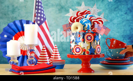 USA theme on-trend candyland fantasy drip cake with decorations in colorful party table setting. Stock Photo
