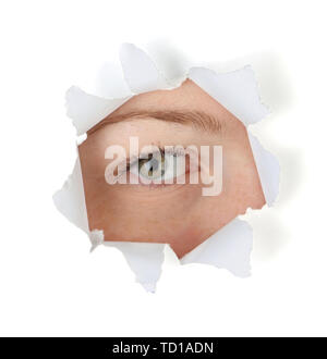 Female eye looking through hole in sheet of paper Stock Photo
