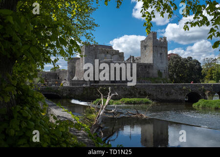 A view of the Castle of Cahir across the weir down the River Suir, bright blue sky and fluffy white clouds, nobody in the image Stock Photo