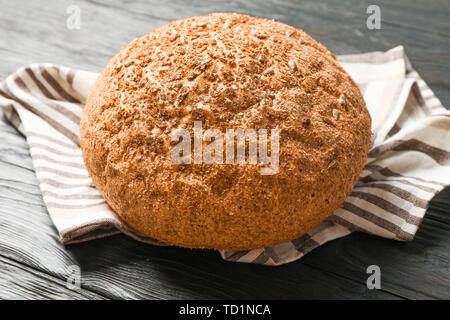 Bread on kitchen towel on wooden background, space for text and closeup Stock Photo