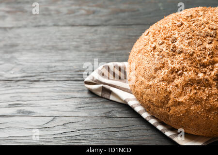 Bread on kitchen towel on wooden background, space for text and closeup Stock Photo