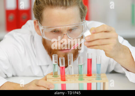 man scientist using auto-pipette with flask in medical science laboratory Stock Photo