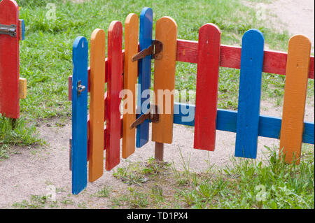 Multi-colored fence strips and wickets at the entrance to garden Stock Photo