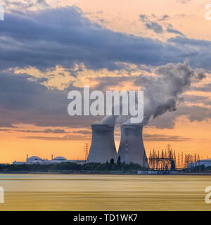 Riverbank with nuclear power plant Doel during a sunset with dramatic cluds, Port of Antwerp, Belgium Stock Photo