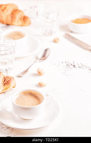 Traditional breakfast with fresh croissants on white background, vertical. Stock Photo