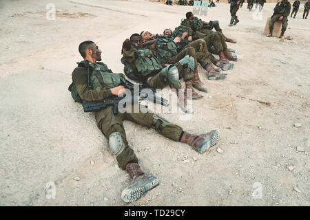 Masada, Israel. 23 October 2018: Soldiers of the Israeli Army lying on the ground and resting after maneuvers and march-throw in fortress of Masada. Stock Photo