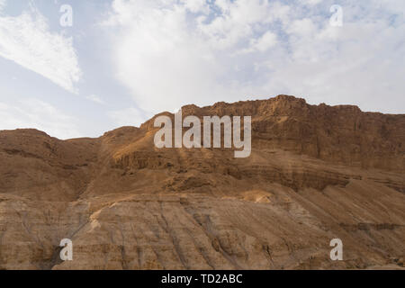 Dusty, dry view of the arid Judean Desert of Israel, at the west bank of the Jordan river. Droughty area and terracotta cliff against the scyscape Stock Photo