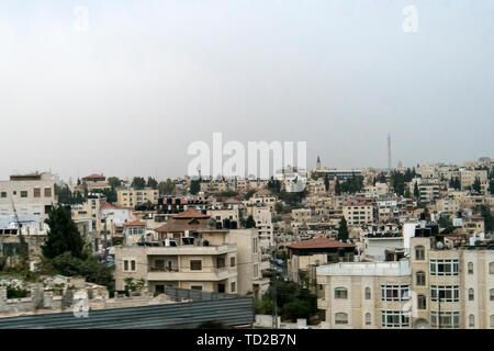 Roofs of a town seen from above, Israel. Aerial view of city at white misty sky background. Early morning, urban life. Sleepy town at the sunrise Stock Photo