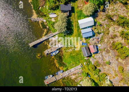 Aerial of a small fishing camp with sheds, boats and jetties. Location Hasslo island in Blekinge archipelago, Sweden. Stock Photo